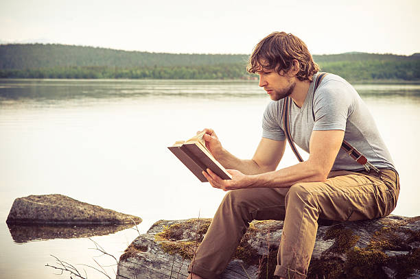 istock Young Man reading book outdoor Summer vacations Lifestyle 500580317