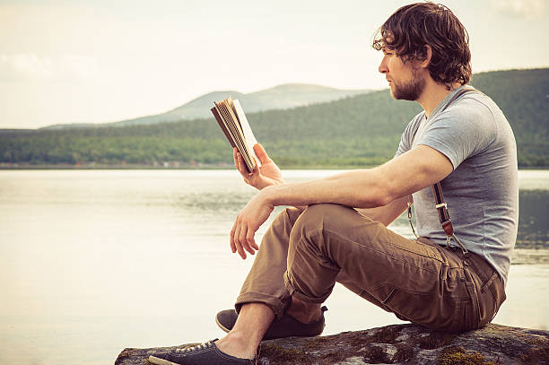 istock Young Man reading book outdoor Summer vacations Lifestyle 500580351