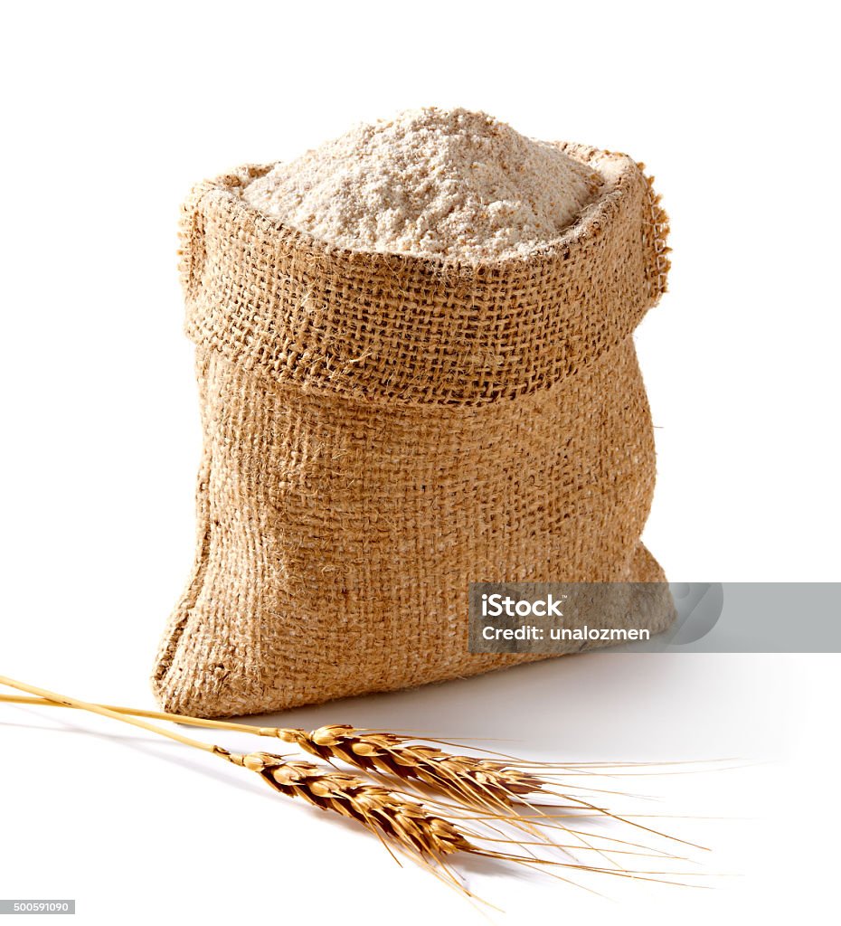 Whole flour in bag with wheat ears Whole flour in burlap on white background Flour Stock Photo