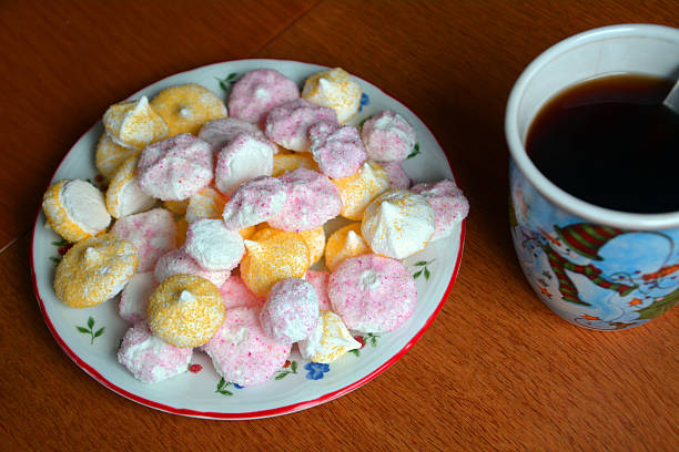 istock Pink And Yellow Meringues On A Plate And Coffee Cup 500593132