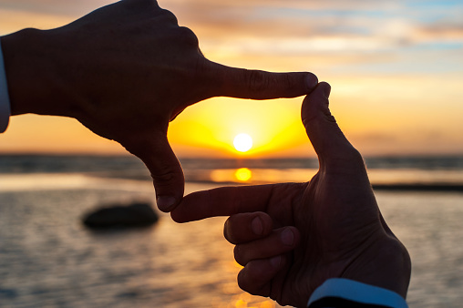 Composición dedo frame- man's hands Disfrute de la puesta de sol photo
