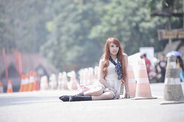 fashion of asia young women sitting on park way