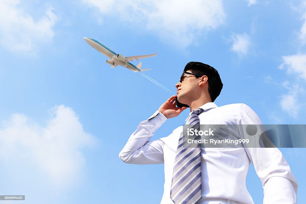 Business man talking on smart phone Business man talking on smart phone with sky Adult Stock Photo