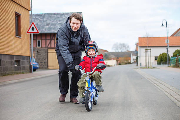 istock Young father teaching  little son to ride a bike 500595467