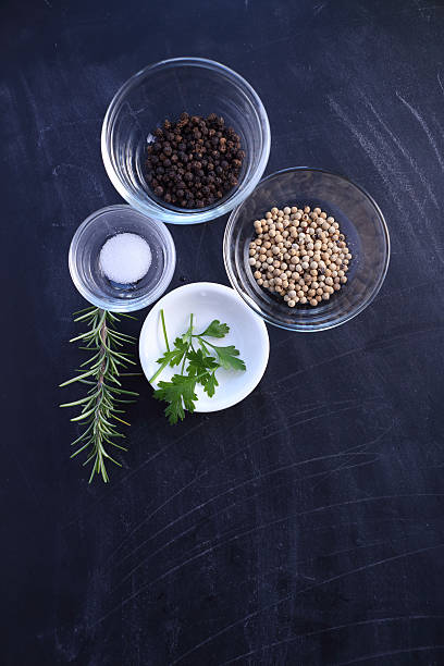 Pepper and salt in bowl on black background