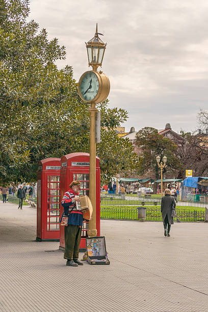 Buenos Aires, Argentina - August 22, 2015: Man dressed as a clown playing the accordion in recoleta park in Buenos Aires, Argentina.