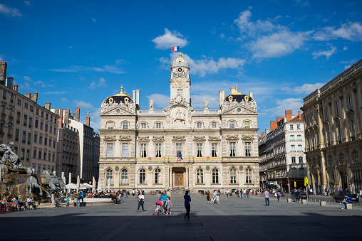 Lyon, France - May 23, 2014: Pedestrians walk outside the Hôtel de Ville, or City Hall,  located on the Place des Terreaux in Lyon, France.