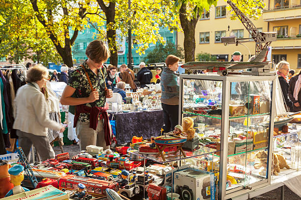 Man admiring stand with vintage tin toys on outdoor market. stock photo
