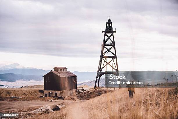 Rugged Man Carrying Pickaxe Over Shoulder Walking Through Western Field Stock Photo - Download Image Now