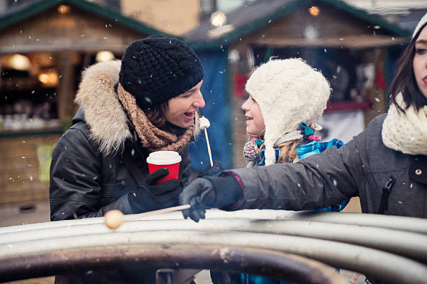 istock Roasting marshmallow at an outdoors winter public market. 500613452