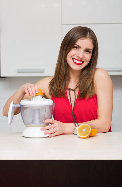 bella donna nella sua cucina - human lips orange lipstick human mouth foto e immagini stock