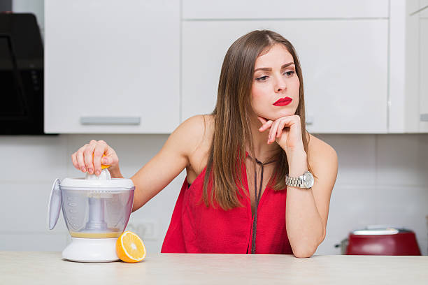 bella donna nella sua cucina - human lips orange lipstick human mouth foto e immagini stock