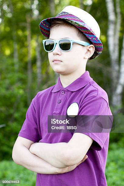 The Boy In A Cap And Glasses Stands Outdoors Stock Photo - Download Image Now - 6-7 Years, Arts Culture and Entertainment, Boys