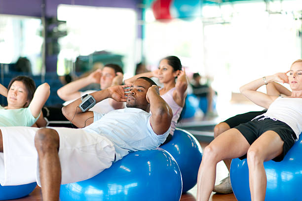 Working out Diverse group of people in gym doing exercise exercise class stock pictures, royalty-free photos & images