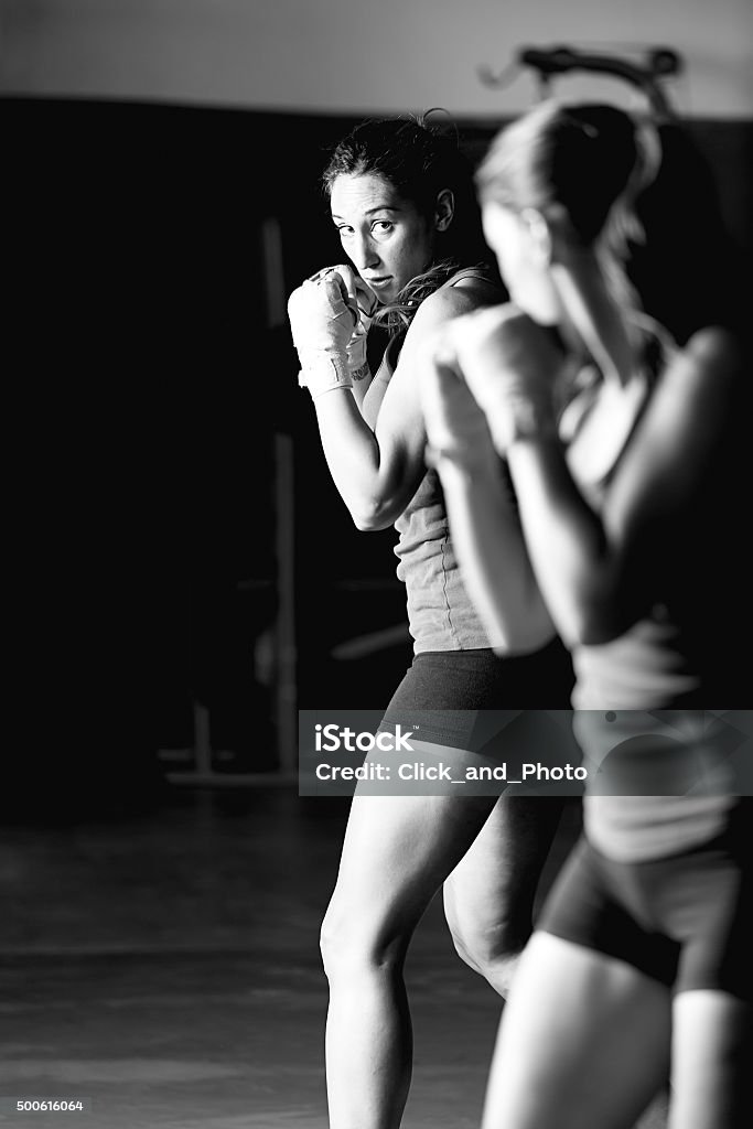 female boxer training Black and white portrait of female boxer fighting and looking in the mirror 2015 Stock Photo