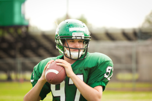 American football player quarterback throwing a pass in a game.