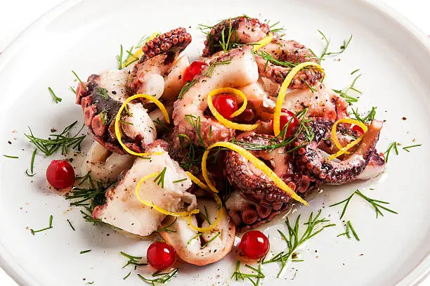 Close-up of Octopus Salad in plate on white background.