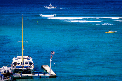 USA, Hawaii, Oahu, Waikiki, boat dock and surfing waves.