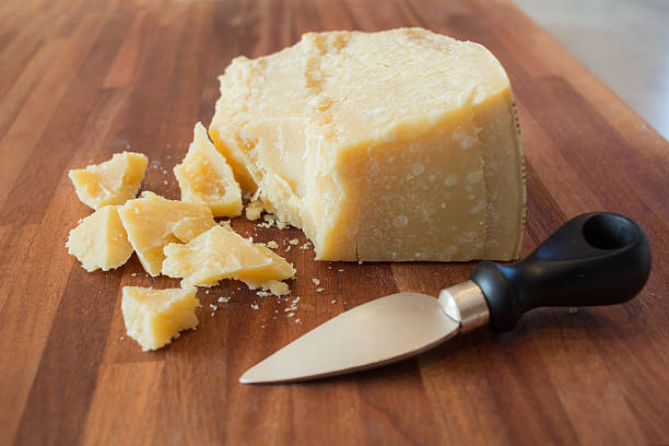 cheese pieces of parmesan cheese on a wooden cutting board grana padano stock pictures, royalty-free photos & images
