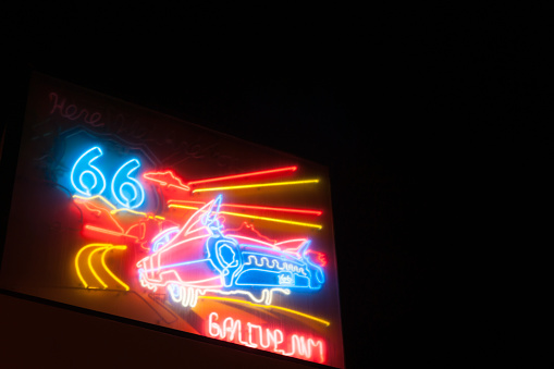 Gallup, NM, USA - September 21, 2015: Night images signs, iconic retro style neon with classic American car graphic for  Route 66 Gallup New Mexico Route 66 on dark sky background.