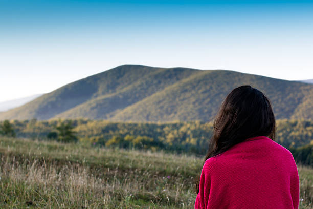 istock girl looking afar on the Carpathians Mountains background 500621590