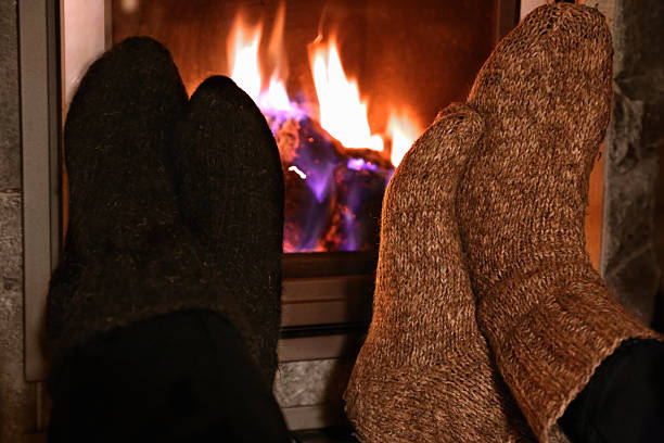 istock Feet in wool socks warming at the fireplace 500621716