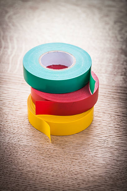 istock Insulating tapes on wooden board electricity concept 500626278