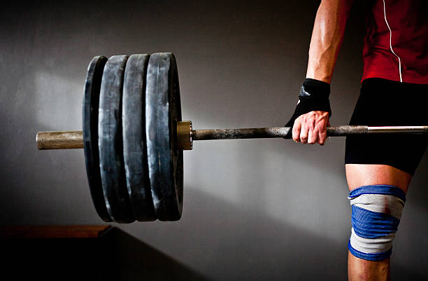 Man practising weightlifting III a photo of a man lifting barbell and disks powerlifting stock pictures, royalty-free photos & images