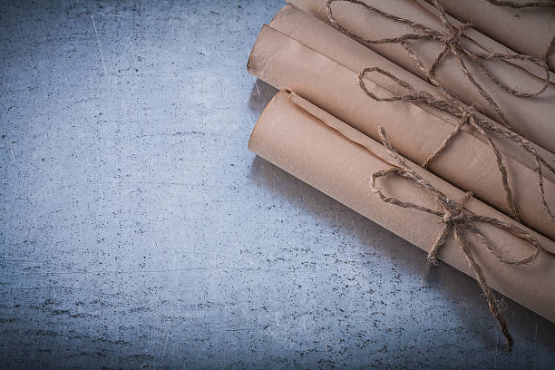 istock Pile of vintage paper rolls on scratched metallic surface 500627384