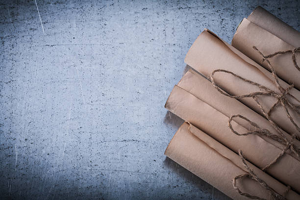 istock Pile of vintage paper scrolls on scratched metallic background 500627400