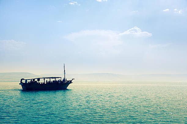 Sea of Galilee Sea of Galilee, Israel, Boat in sunset, Golan Heights in the background sea of galilee stock pictures, royalty-free photos & images