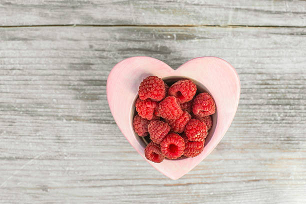 istock Raspberries in a bowl on wood 500646174