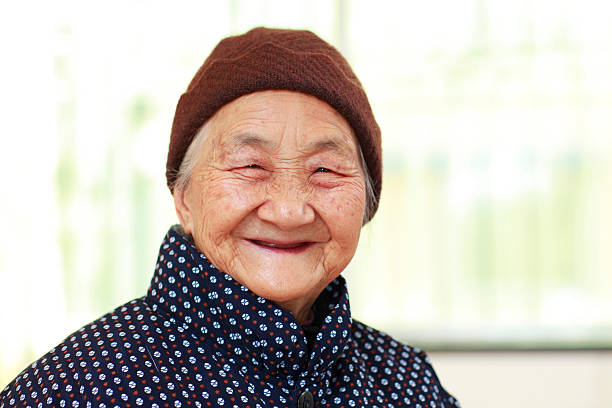 one happy senior Chinese female looking at camera smile