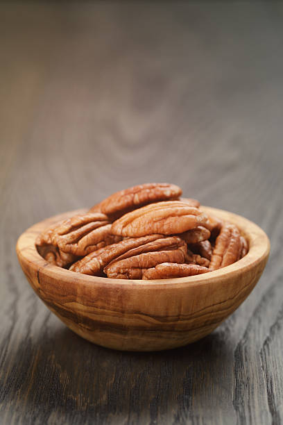 istock pecan nuts in olive wood bowl on oak table 500647198