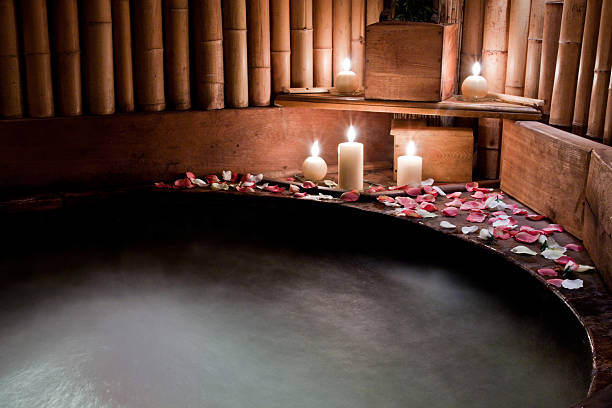 romantisches spa-whirlpool mit rosenblättern - wellness kerzen stock-fotos und bilder