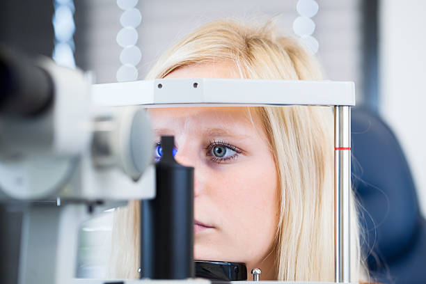 hermosa mujer joven con los ojos examinados por optometrics - doctor reading chart human eye fotografías e imágenes de stock