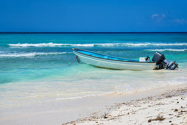 A brightly coloured wooden fishing boat in the turquoise waters of theCaribbean Sea.