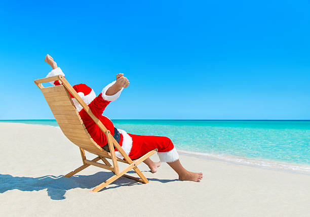 christmas santa claus desfrutar de sol na praia de areia deckchair - christmas beach sun tropical climate imagens e fotografias de stock