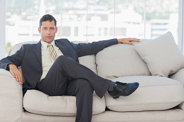 istock Serious businessman in suit posing sitting on sofa 500649489