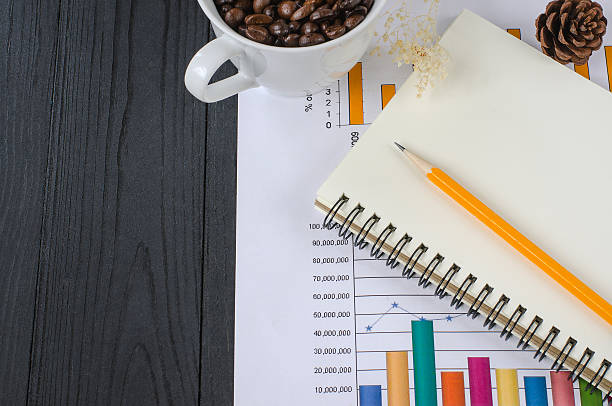 istock Note book and pencil on business graph on wooden 500650576