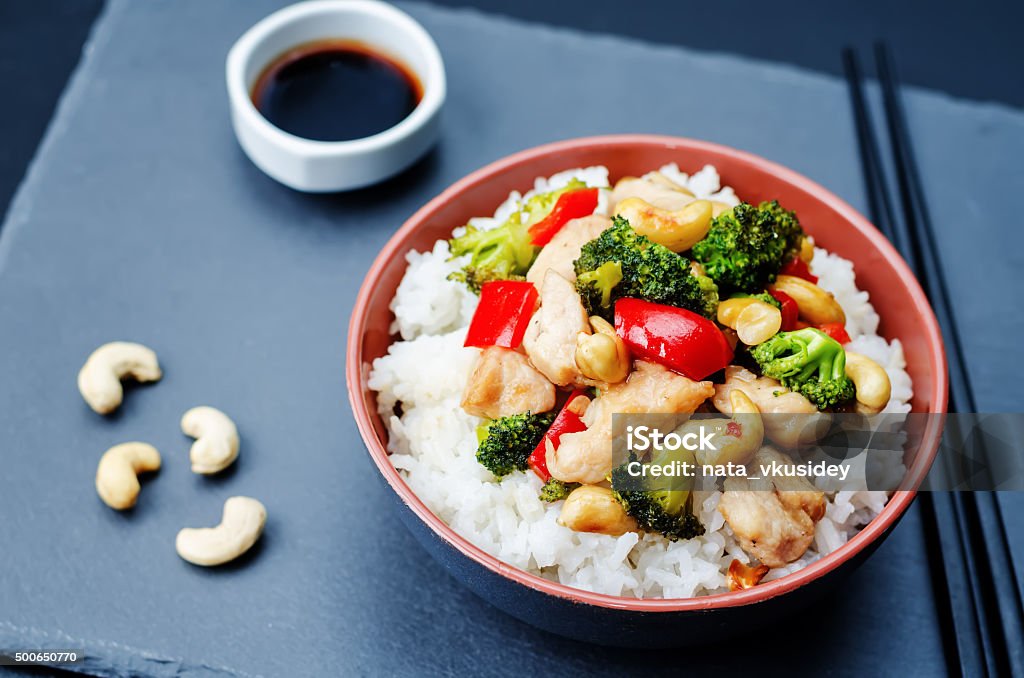 red pepper broccoli cashew chicken stir fry with rice red pepper broccoli cashew chicken stir fry with rice. toning. selective Focus Asian Food Stock Photo