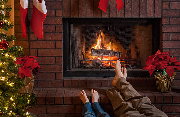 istock cozy Christmas fireplace with father and son warming feet 500650784