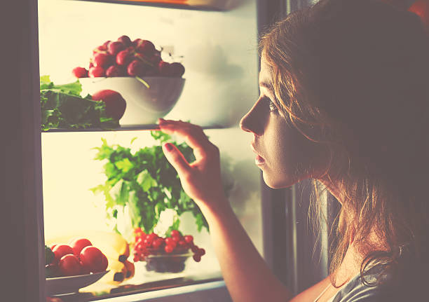 istock night hunger. Woman in the dark at open refrigerator 500650796