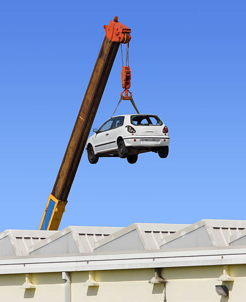 Car Hanging by the Arm of a Crane stock photo