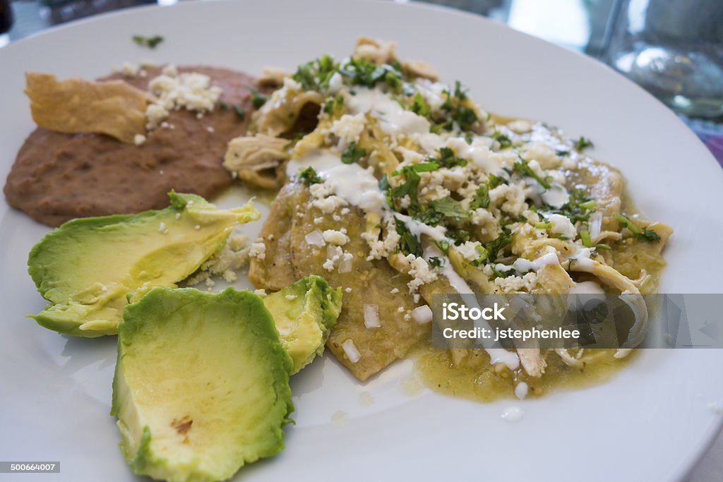 Chilaquiles with Green Sauce Chilaquiles with green salsa, cilantro, avocado, and cheese Chicken - Bird Stock Photo