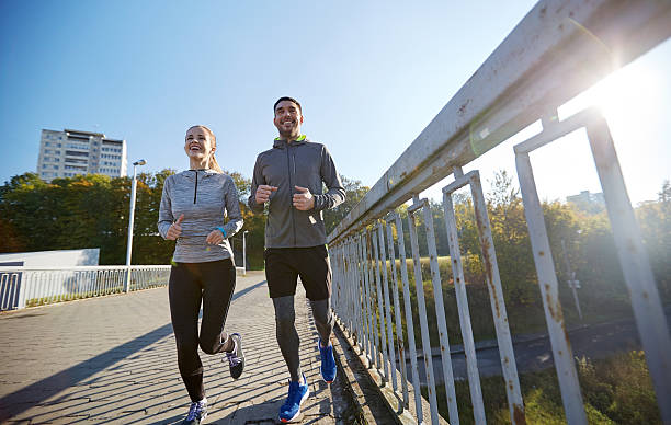 istock happy couple running outdoors 500664442