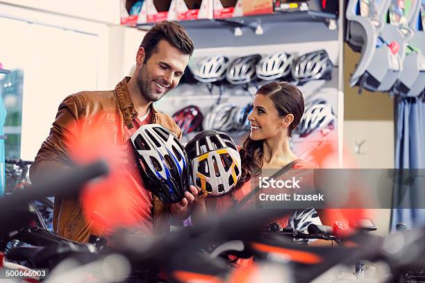 Couple Bying Bike Helmets Stock Photo - Download Image Now - Buying, Cycling Helmet, People