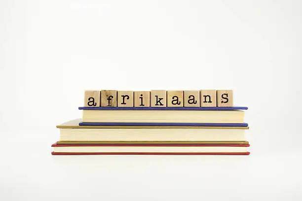 Photo of Afrikaans language word on wood stamps and books