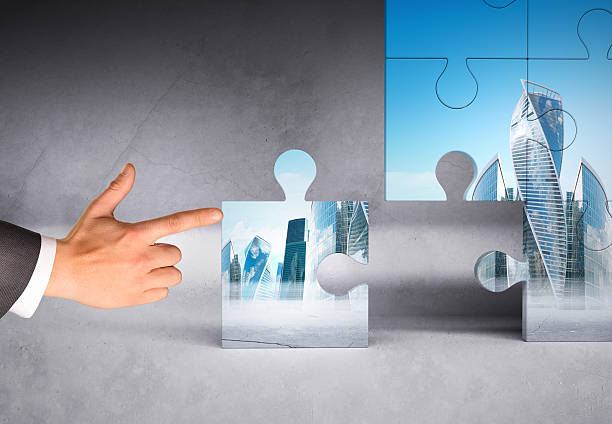 istock Man hand pushing puzzle piece of modern city 500666408