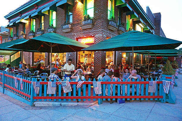 Washington DC, USA-July 7, 2014:  These diners are dining at a neighborhood Mexican restaurant in Cleveland Park in Northwest Washington DC after the fourth of July on a Monday night.  American flags adorn the fence and these people are extending their fourth of July weekend by dining out.